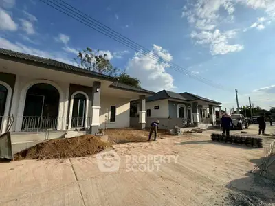Modern single-story homes under construction with clear blue sky backdrop.
