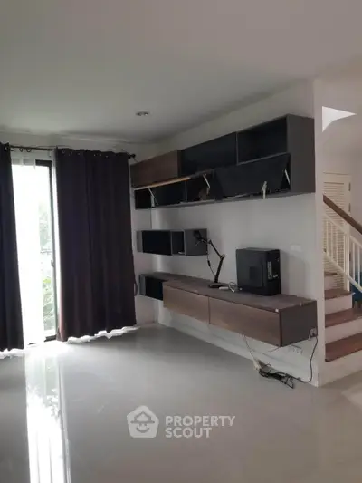 Modern living room with sleek shelves and large window, perfect for stylish urban living.