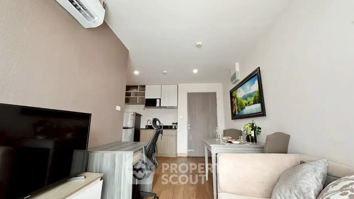 Modern living room with open kitchen, featuring sleek furniture and stylish decor.