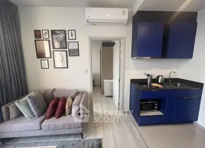 Modern living room with stylish blue kitchen cabinets and cozy sofa