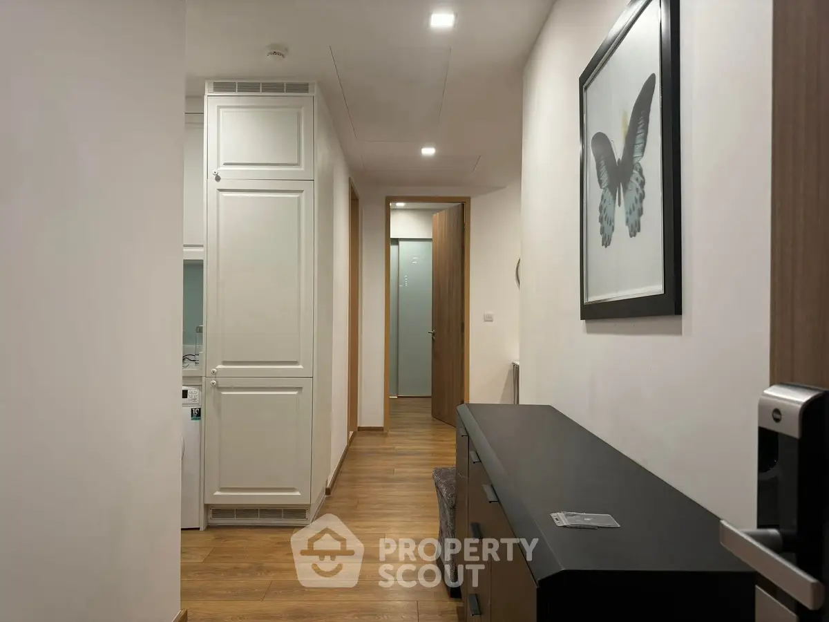 Stylish hallway with wooden flooring and modern decor in a contemporary apartment.