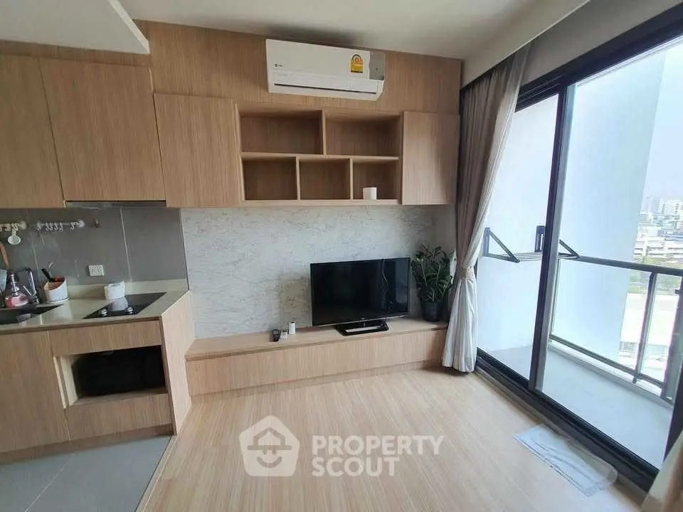 Modern living room with wooden flooring, built-in TV unit, and balcony view.
