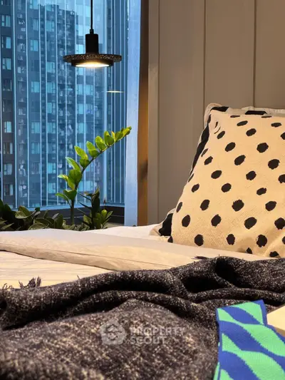 Modern bedroom with city view, stylish decor, and cozy ambiance.