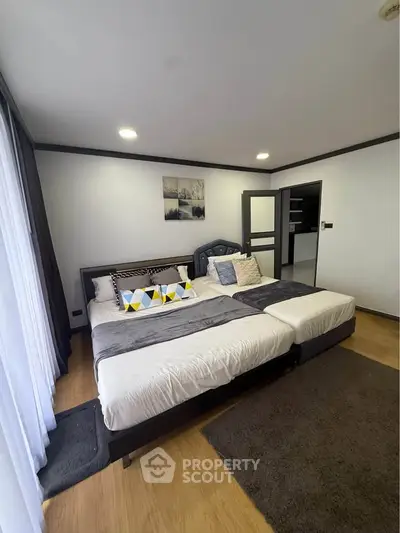 Spacious modern bedroom with stylish decor and ample natural light.
