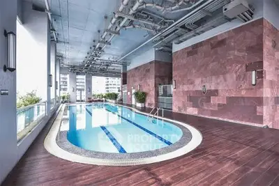 Luxurious indoor pool with modern design and city view, perfect for relaxation and leisure.