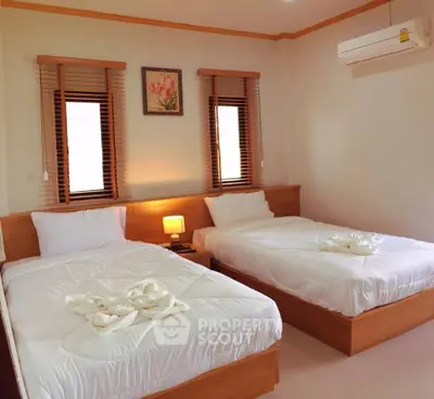 Cozy bedroom with twin beds, air conditioning, and elegant decor for a comfortable stay.