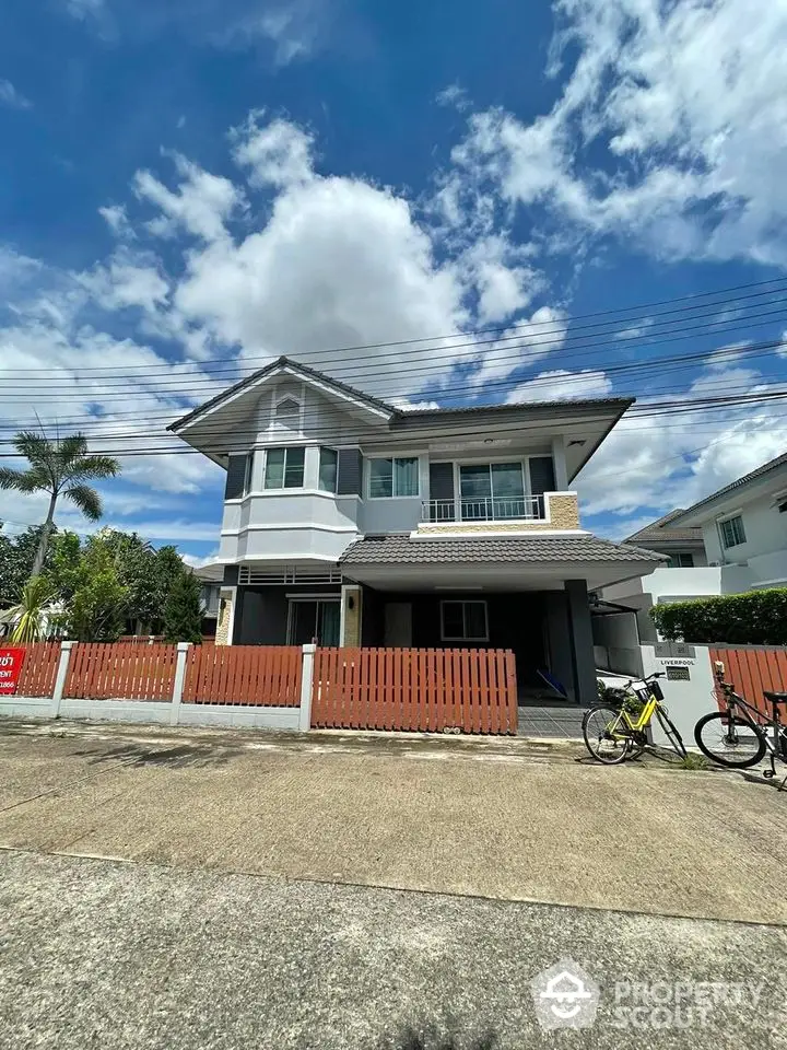 Charming two-story house with modern design and spacious front yard in a serene neighborhood.