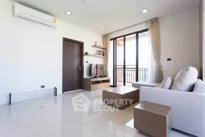 Modern living room with sleek furniture and balcony view, perfect for urban living.