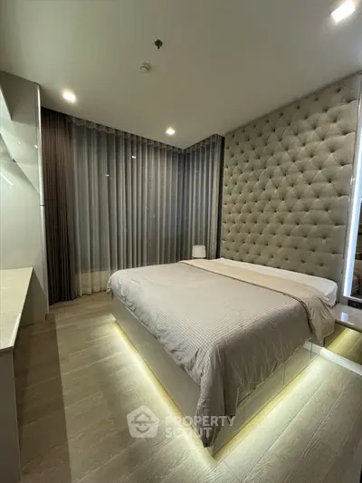 Luxurious modern bedroom with tufted wall and ambient lighting