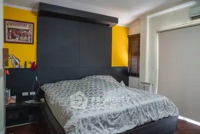 Cozy bedroom with modern decor and vibrant yellow accent wall