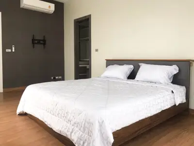 Spacious modern bedroom with wooden flooring and minimalist decor