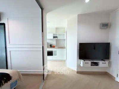 Modern open-plan living room with sleek kitchen and mounted TV, perfect for contemporary living.