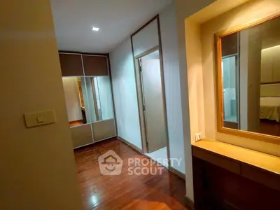Spacious bedroom with wooden flooring and built-in wardrobe in modern apartment