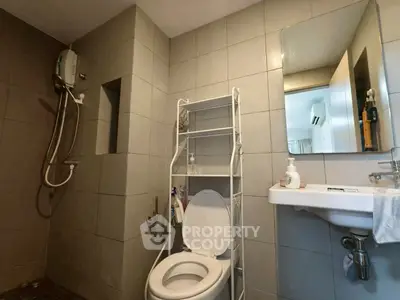 Modern bathroom with sleek tiles and essential fixtures, perfect for a contemporary home.