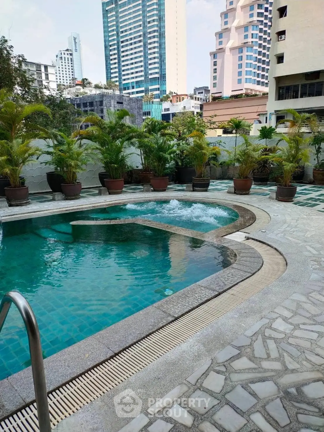 Luxurious urban swimming pool with lush greenery and cityscape views