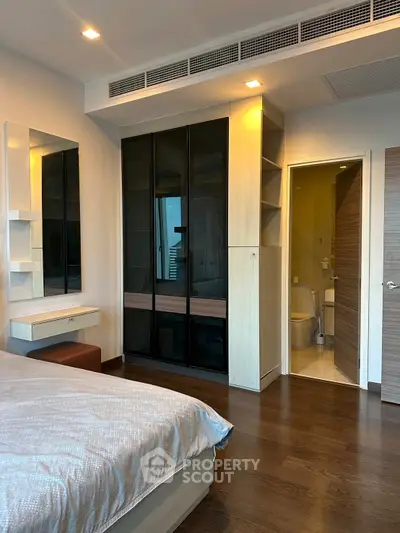 Modern bedroom with ensuite bathroom and stylish wardrobe in a contemporary apartment.