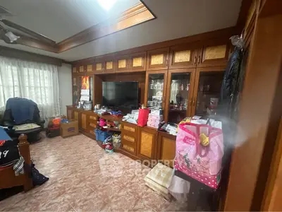 Spacious living room with built-in wooden cabinets and large window, perfect for cozy family gatherings.