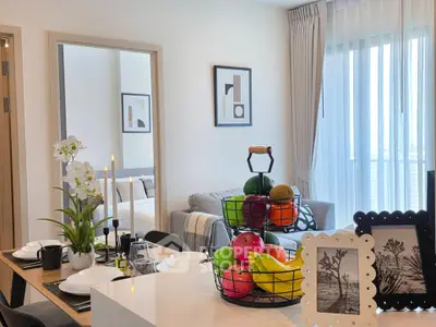 Modern dining area with elegant decor and fruit basket in a stylish apartment.