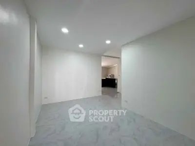 Spacious modern interior with sleek flooring and recessed lighting, ideal for versatile living.