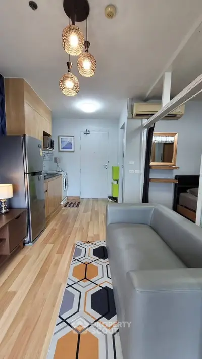 Modern open-plan living room with stylish decor and kitchen appliances in a cozy apartment.