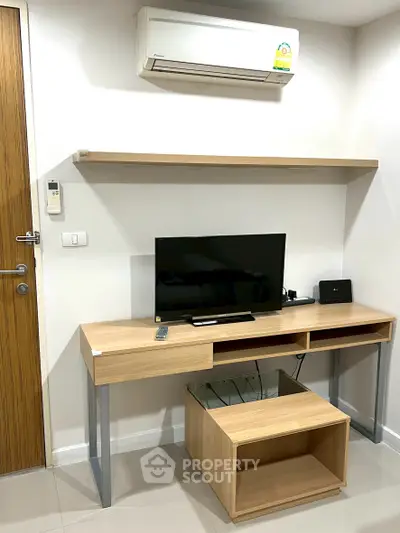 Modern living room with sleek TV stand, air conditioning, and minimalist decor.