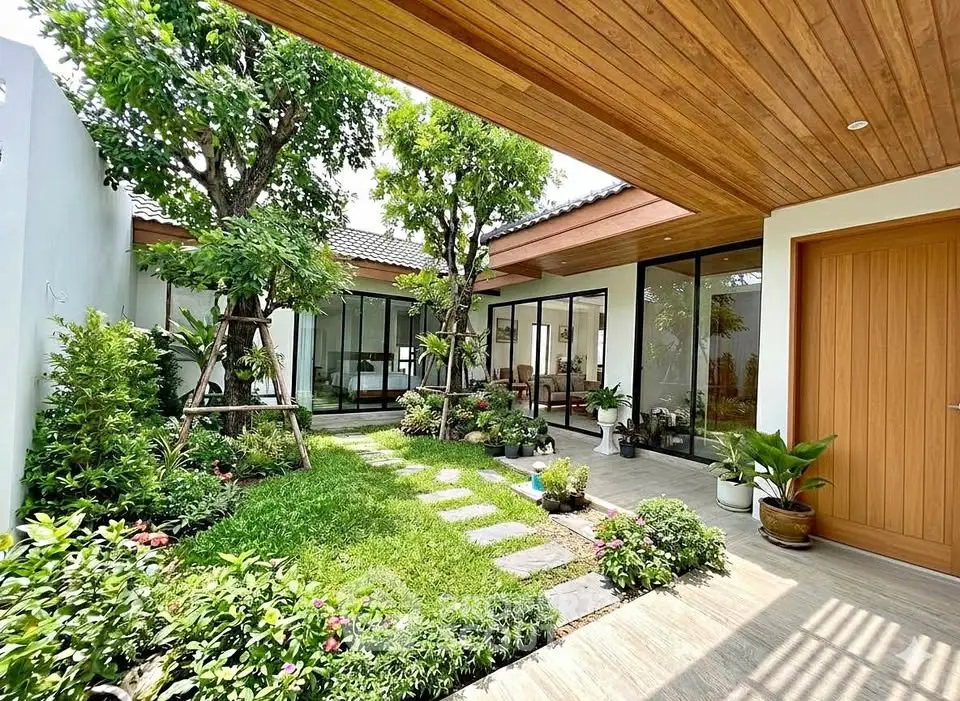 Modern home with lush garden and wooden ceiling accents