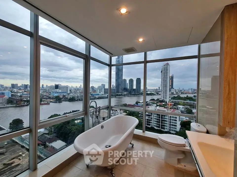 Luxurious bathroom with stunning city and river views from floor-to-ceiling windows.