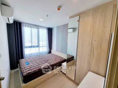 Modern bedroom with large window and wooden furniture in a stylish apartment.