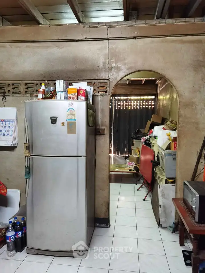 Cozy kitchen with vintage fridge and archway leading to storage area