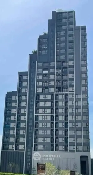 Modern high-rise building with sleek design and large windows in urban setting.