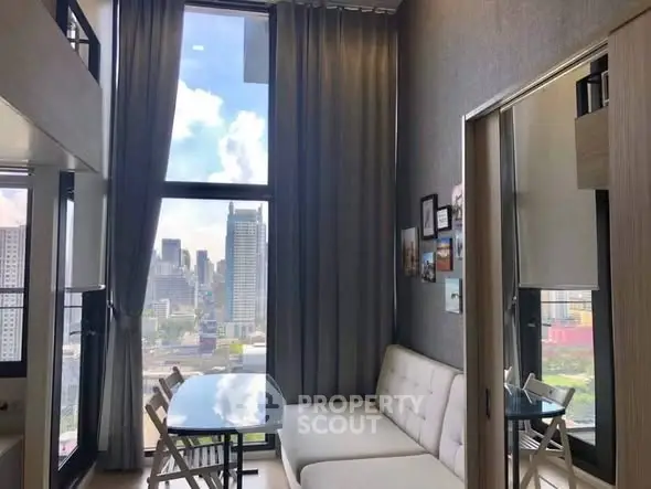 Modern living room with large windows offering stunning city views and stylish decor.