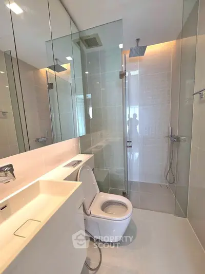 Modern bathroom with sleek design, glass shower, and elegant fixtures in a contemporary apartment.