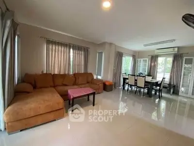 Spacious living room with large sofa and dining area, perfect for family gatherings.