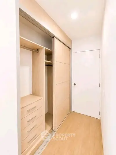 Spacious walk-in closet with sliding doors and ample storage in modern home.