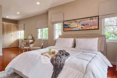 Spacious bedroom with elegant decor and large windows offering natural light and garden views.