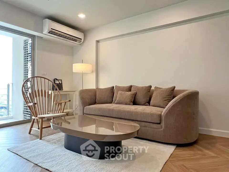 Modern living room with stylish furniture and natural light, featuring a cozy sofa and elegant coffee table.