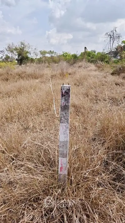 Vacant land plot with boundary marker in a grassy field, ideal for development opportunities.