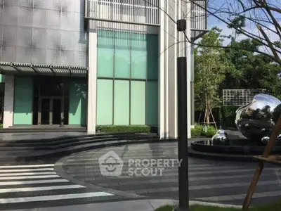 Modern building entrance with sleek design and reflective sculptures