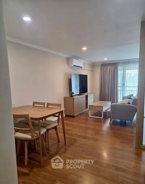 Spacious living room with modern furniture and wooden flooring in a stylish apartment.