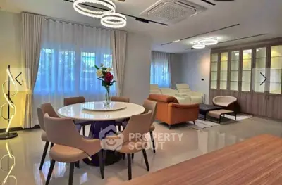 Spacious modern living room with elegant dining area and stylish lighting fixtures.