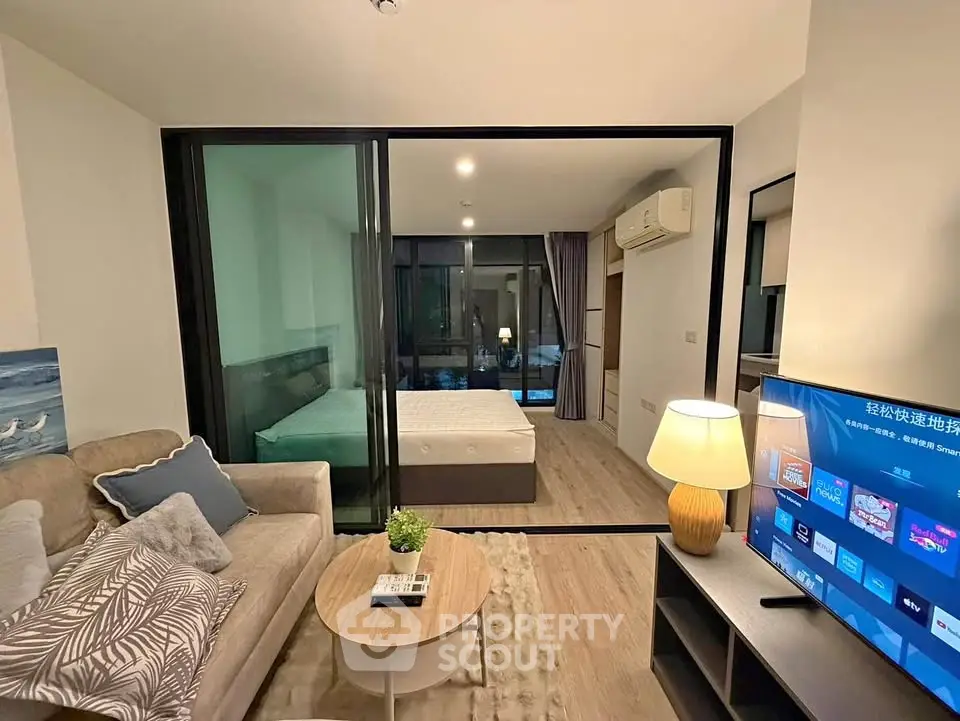 Modern studio apartment with glass partition, cozy living area, and stylish decor