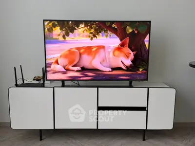 Modern living room with sleek white TV stand and flat-screen TV displaying animated content.