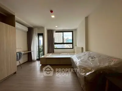 Modern bedroom with large window and city view, featuring sleek wooden furniture and minimalist design.