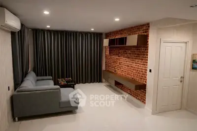 Modern living room with brick accent wall and sleek gray sofa