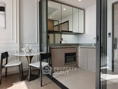 Modern kitchen with sleek cabinetry and dining area in open layout apartment.