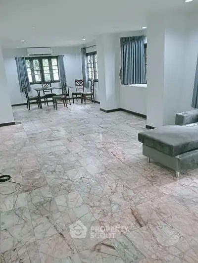 Spacious living room with marble flooring and elegant dining area