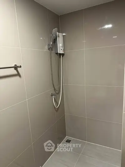 Modern bathroom with sleek shower design and neutral tile finish.