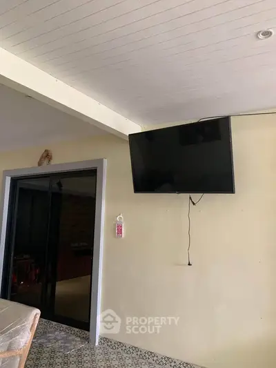 Cozy interior with mounted TV and sliding glass door, perfect for modern living.