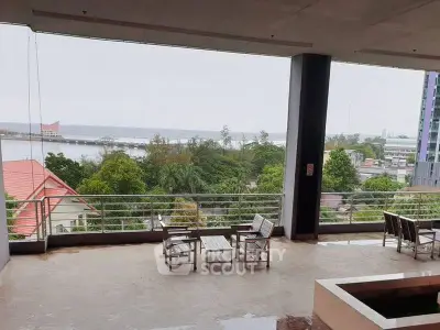 Spacious balcony with stunning ocean view and outdoor seating area.