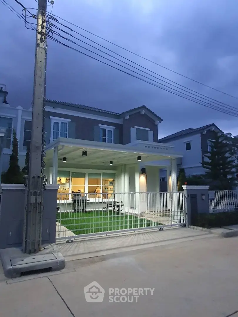 Charming suburban house with modern facade and well-maintained front yard at dusk.